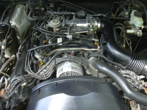 1996 Ford Crown Victoria - Close-up view of a vehicle's engine compartment, showing the alternator and air intake system.