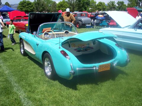 1972 Ford Ranchero - A turquoise convertible with its trunk open, revealing a colorful mural inside, sits on display at a car show.
