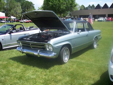 1972 Ford Ranchero - A light blue Studebaker Lark is displayed with its hood open at an outdoor car show.