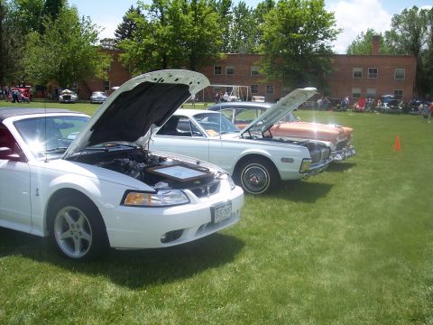 1972 Ford Ranchero - A white convertible is displayed with its hood open at a car show, revealing the engine and a framed item.