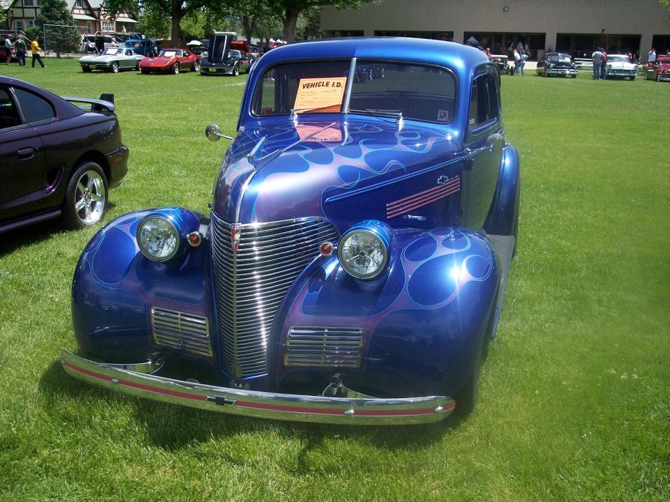 Blue hot rod with flame paint job, front view. Vehicle ID card visible
