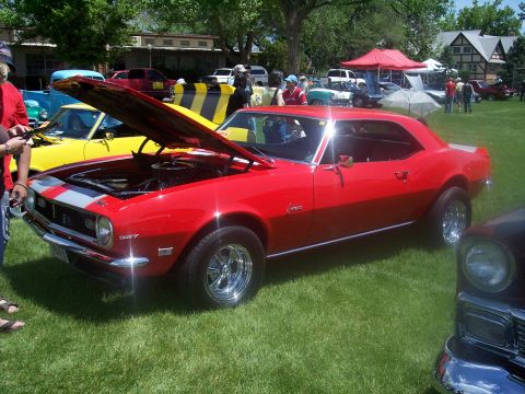 1972 Ford Ranchero - A red 1967 Chevrolet Camaro is displayed at an outdoor car show with its hood open.