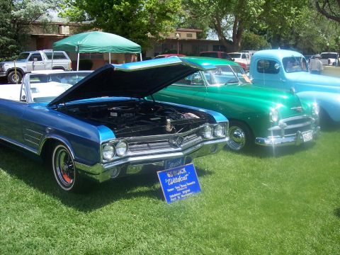 1972 Ford Ranchero - A blue 1965 Buick Wildcat convertible is displayed with its hood open at an outdoor car show.