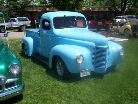 1972 Ford Ranchero - A light blue pickup truck is parked on the grass at a car show, with other vehicles visible in the background.