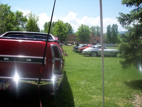 1972 Ford Ranchero - A red 1972 Ford Ranchero is parked on a grassy field at a car show with other vehicles in the background.