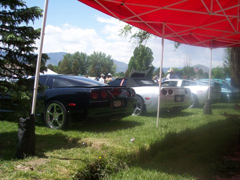 1972 Ford Ranchero - Multiple Corvettes, including a black C5 and a silver C5, are displayed at an outdoor car show.