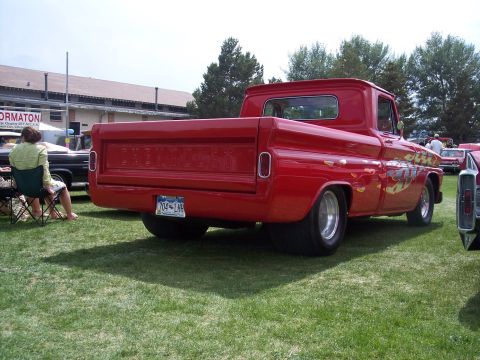 1972 Ford Ranchero - Customized red 1960 Chevrolet C10 pickup truck with flame graphics at a car show.