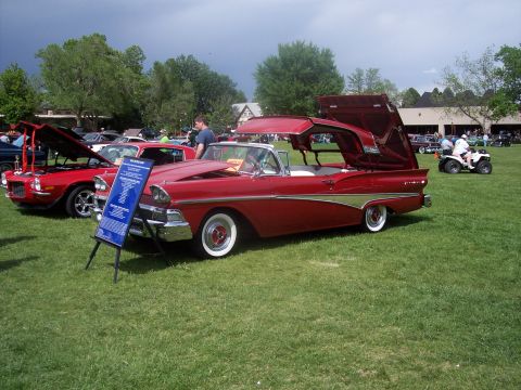 1972 Ford Ranchero - A classic red convertible with its roof and trunk open is displayed at an outdoor car show.