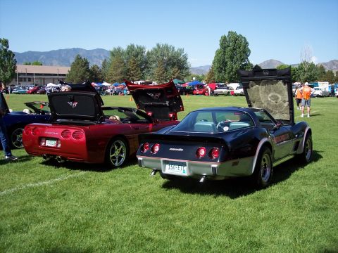 1972 Ford Ranchero - Two Corvettes, one black and one red, are displayed with their hoods or trunks open at an outdoor car show.