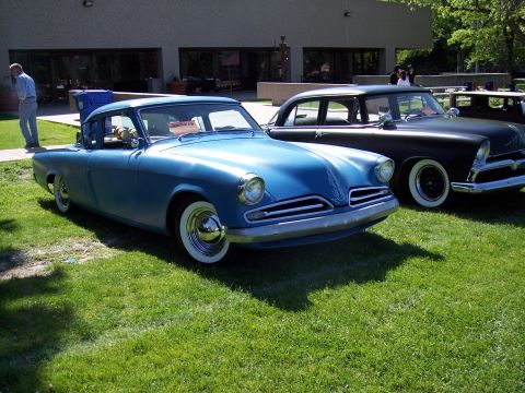 1972 Ford Ranchero - A blue 1955 Studebaker coupe is parked on grass at an outdoor car show.