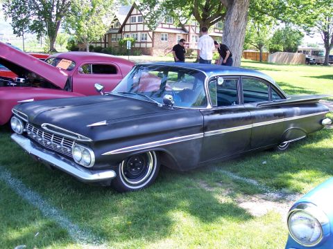1972 Ford Ranchero - A classic black sedan with distinctive tail fins is displayed at an outdoor car show.