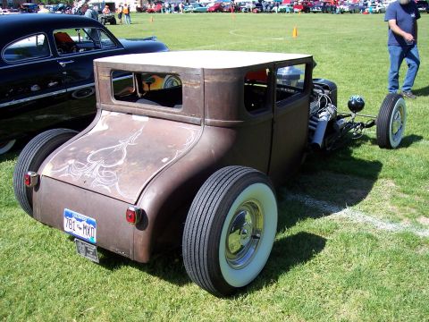 1972 Ford Ranchero - A weathered hot rod coupe with custom pinstriping sits on a grassy field next to other vehicles.