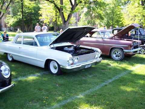 1972 Ford Ranchero - Two classic cars are displayed on a grassy field with their hoods open, suggesting a car show event.