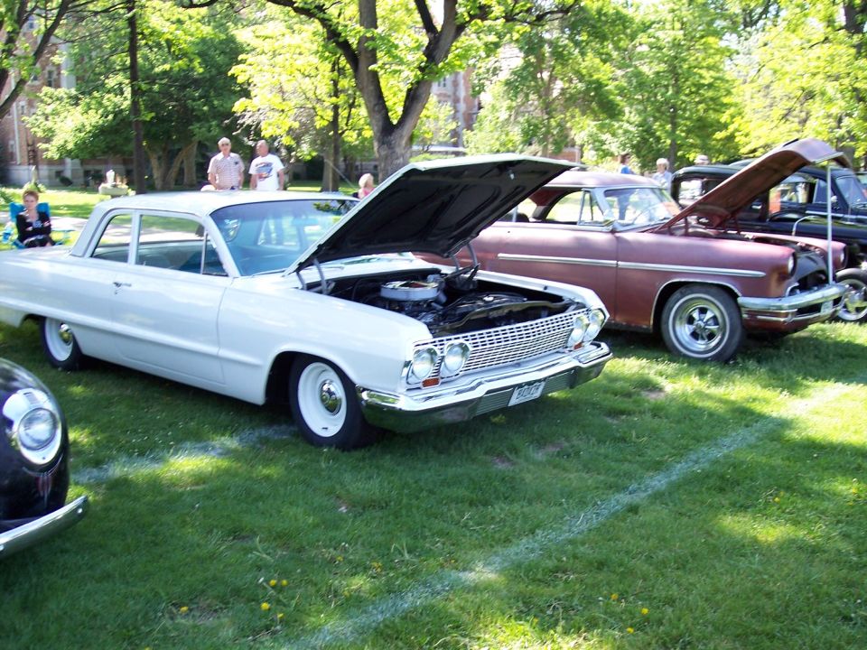 White 1963 Chevrolet Impala with hood open, parked next to a maroon car