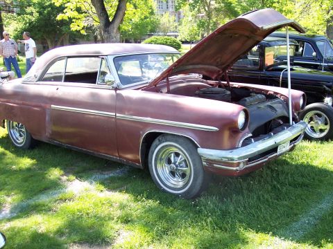 1972 Ford Ranchero - A maroon coupe with its hood open sits on display next to another dark-colored vehicle.