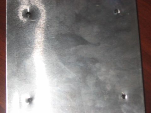 1991 Ford Bronco - Close-up of a metal plate with screw heads, likely a component or cover.