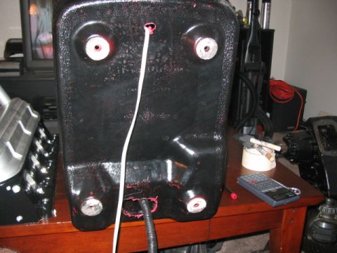 1991 Ford Bronco - A black plastic component with visible wiring and mounting bolts is shown on a wooden table.
