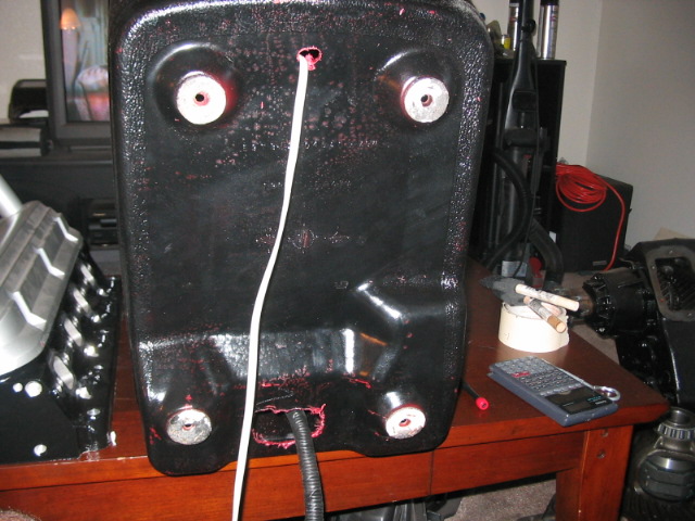 Black plastic part with wires and bolts