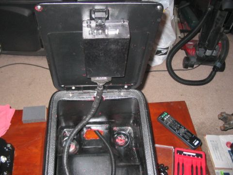 1991 Ford Bronco - The interior of a vehicle's center console is open, revealing electrical wiring and connections.