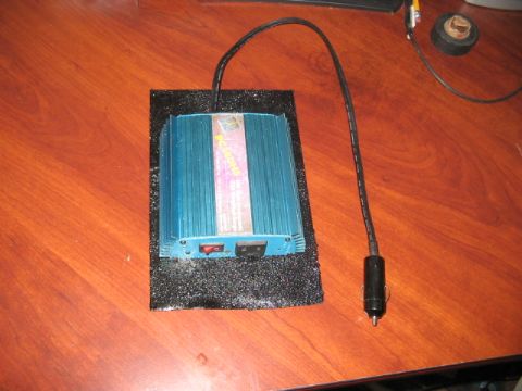 1991 Ford Bronco - A blue power inverter with a car adapter is placed on a wooden desk.