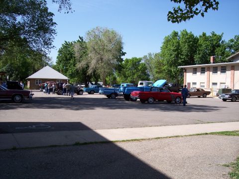 1972 Ford Ranchero - Several classic cars and trucks are gathered in a parking lot under a clear blue sky.