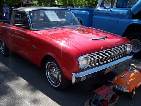 1972 Ford Ranchero - A red 1962 Ford Ranchero with a grey roof is displayed at a car show, with a blue truck visible in the background.
