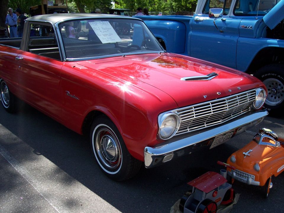 Red 1962 Ford Ranchero with grey roof, parked next to a blue truck