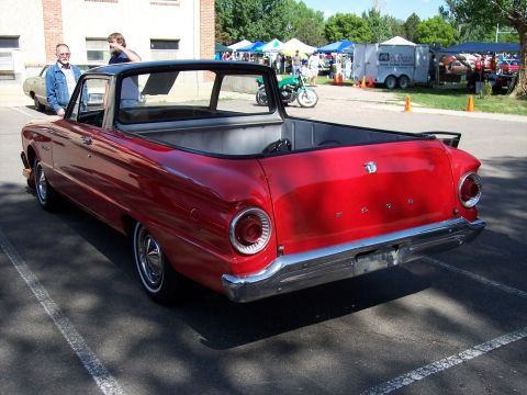 1972 Ford Ranchero - A red Ford Ranchero with a black top is parked at an outdoor event, with other vehicles and tents in the background.