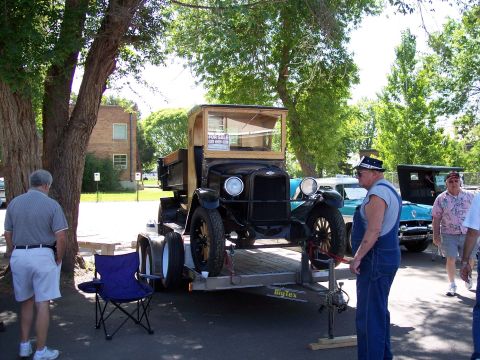 1972 Ford Ranchero - A vintage black truck is displayed on a trailer at an outdoor event, with other vehicles visible in the background.