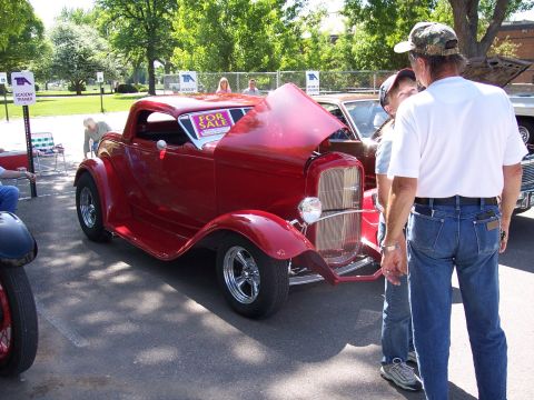 1972 Ford Ranchero - A red coupe hot rod is displayed with its hood up at a car show, a "FOR SALE" sign in the windshield.