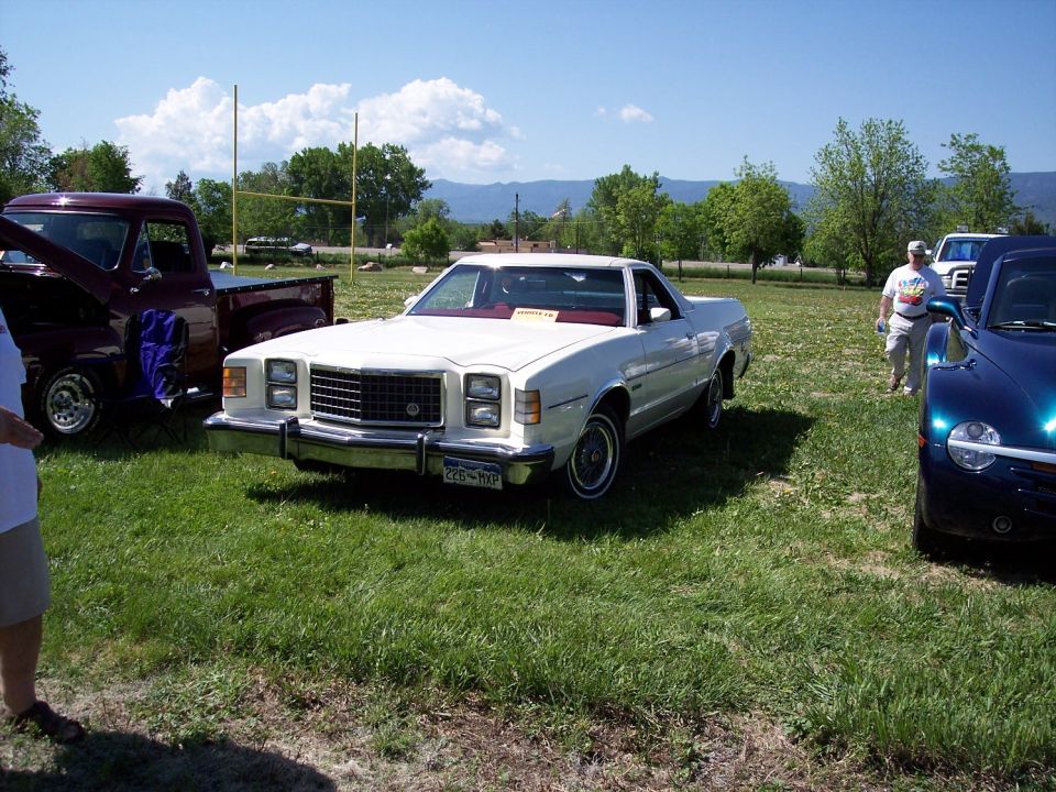 White 1977 Ford Ranchero with a red interior, parked on grass