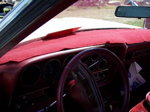 1972 Ford Ranchero - Interior view of a car's dashboard and steering wheel, a red dash cover and visible gauges.