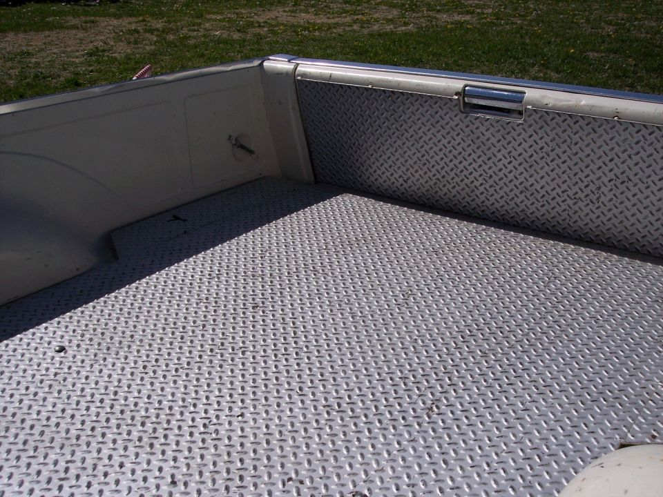Truck bed with diamond plate lining on the floor and sides. Chrome handle on the right side