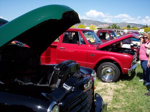 1972 Ford Ranchero - Two vintage pickup trucks are displayed with their hoods open at a sunny outdoor car show.