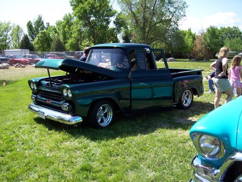 1972 Ford Ranchero - A classic dark green pickup truck is displayed outdoors with its hood open.