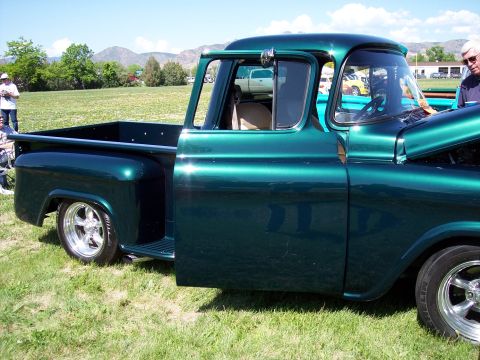 1972 Ford Ranchero - Green pickup truck with custom wheels and hood open, parked on grass at an outdoor event.