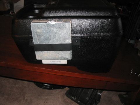 1991 Ford Bronco - A black textured plastic storage box with a metal component secured by a black strap is visible.