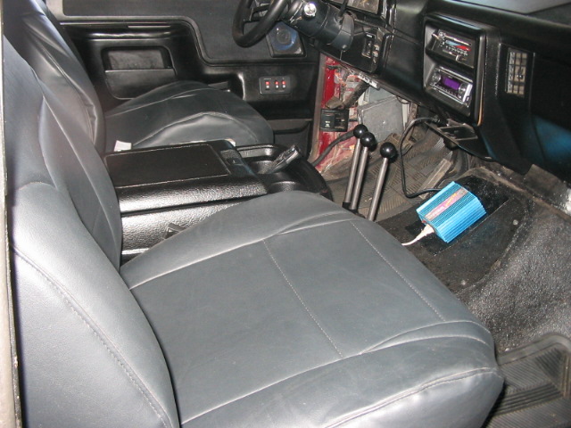 Interior view of a truck showing front seats, dashboard, and center console with gear shifters