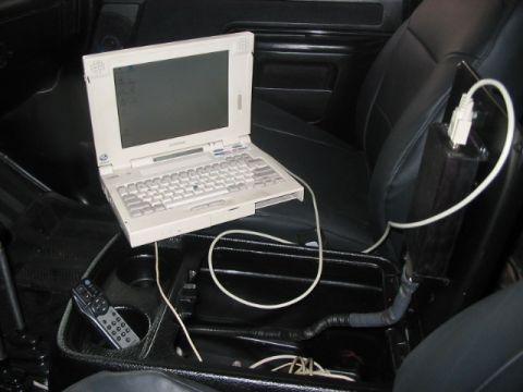 1991 Ford Bronco - A laptop and remote control are visible inside a vehicle's cabin.