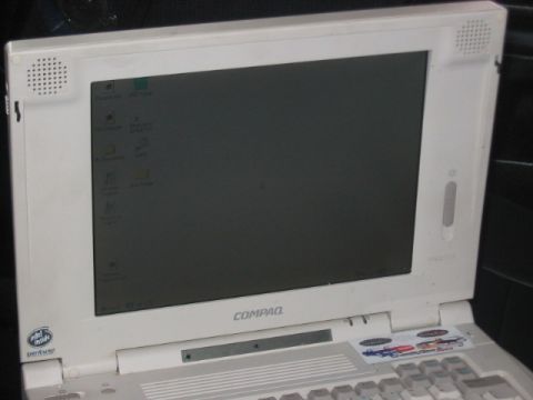 1991 Ford Bronco - A white Compaq laptop computer is shown with its screen open, displaying the operating system desktop and various icons.