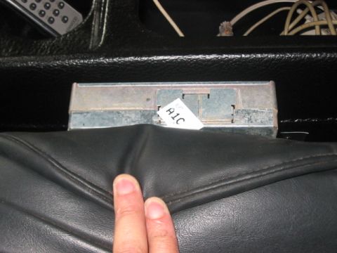 1991 Ford Bronco - A metal electronic part with a label is visible inside a vehicle's interior.