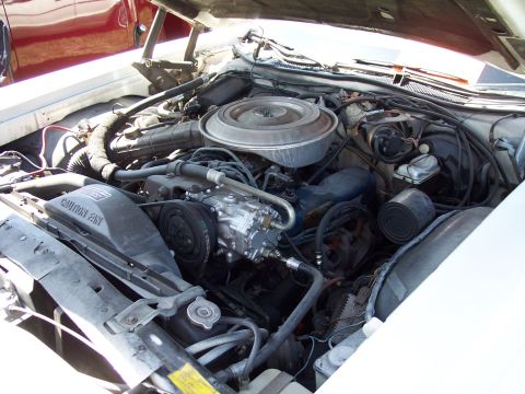 1972 Ford Ranchero - The engine bay of a vehicle is shown, with various components like the air cleaner, compressor, and fan clearly visible.