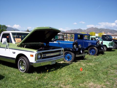 1972 Ford Ranchero - Several classic vehicles are lined up on a grassy field under a clear blue sky.