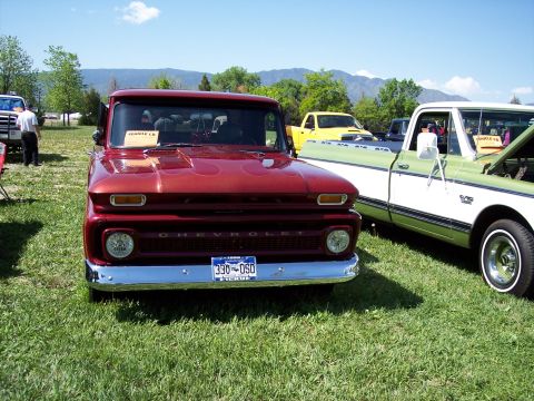 1972 Ford Ranchero - A red 1964 Chevrolet pickup truck with flame decals is parked on grass at a car show next to other vehicles.