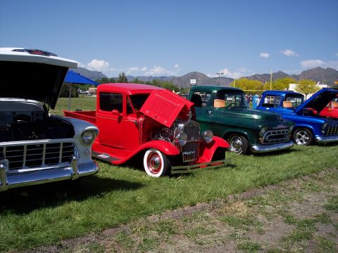 1972 Ford Ranchero - Several classic pickup trucks are lined up on a grassy field under a clear blue sky.