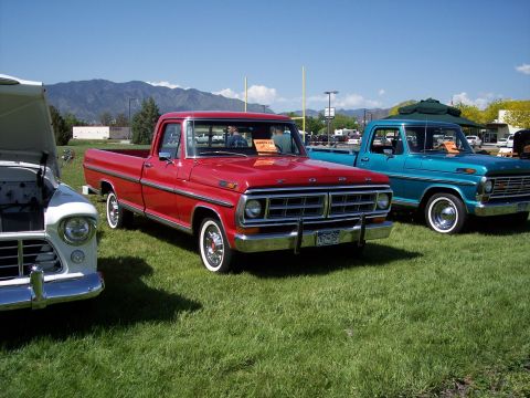 1972 Ford Ranchero - A red 1970 Ford pickup truck is displayed at a car show with other vehicles.