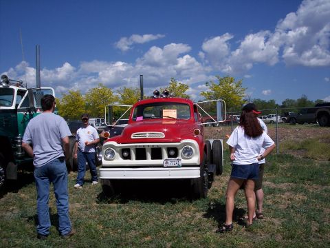 1972 Ford Ranchero - A red and white truck is parked on grass with people around it at an outdoor event.