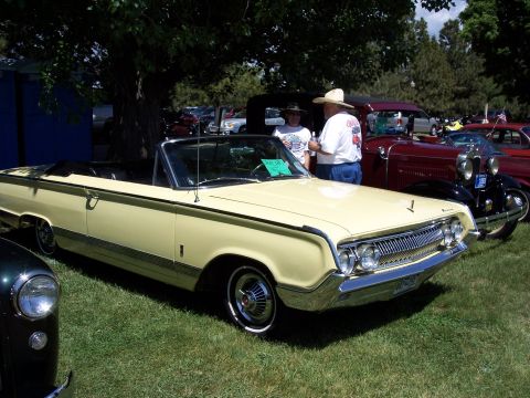 1972 Ford Ranchero - A yellow 1963 Mercury Marauder convertible is displayed at a car show with other vehicles in the background.
