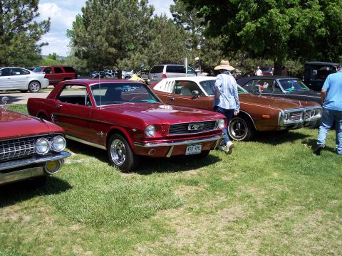 1972 Ford Ranchero - A classic red Ford Mustang is displayed at an outdoor car show alongside other vintage vehicles.