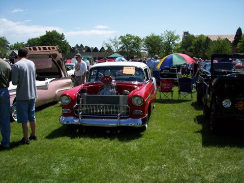 1972 Ford Ranchero - A red and white 1955 Chevrolet Bel Air is displayed with its hood open at an outdoor car show.